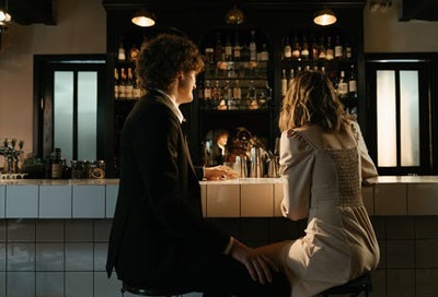 A photo of a man and woman on a date, sitting in a bar
