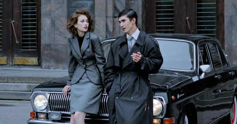 A photo of a couple standing in front of a car.